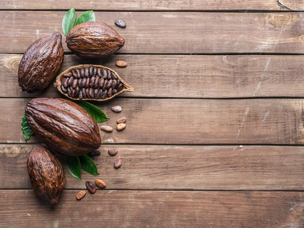 Cacaopod en cacaobonen op de houten tafel. Bovenaanzicht. — Stockfoto