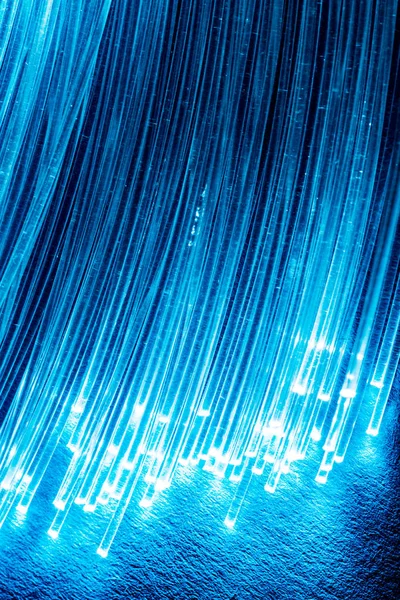 光纤束, 两端有灯光。蓝色背景 — 图库照片