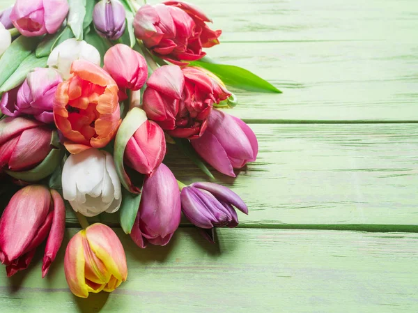 Kleurrijk boeket tulpen op groene houten achtergrond. — Stockfoto