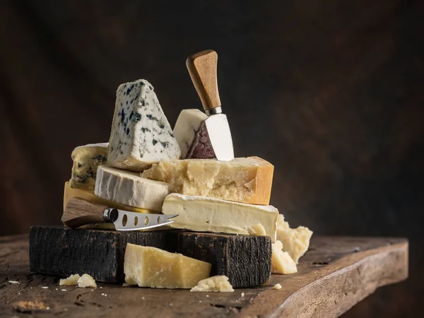 在木制背景上的不同类型的奶酪的分类。切斯 — 图库照片