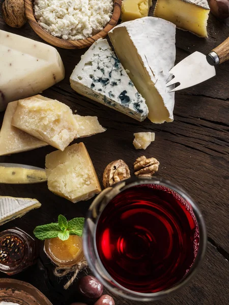 Piatto di formaggio con formaggi biologici, frutta, noci e vino su wo — Foto Stock