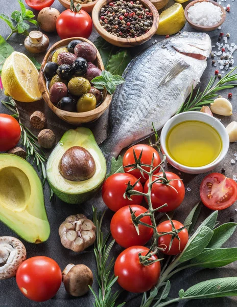 Pescado dorado crudo con especias y verduras en la pizarra de grafito — Foto de Stock