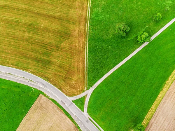 De kruising van wegen en kleurrijke velden. Luchtfoto. — Stockfoto