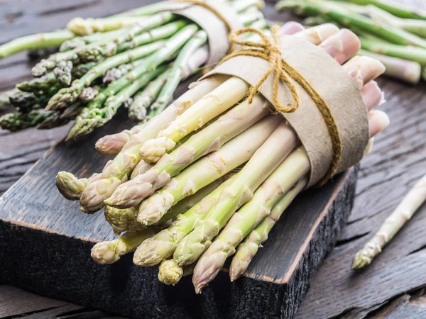 Bundles of green and white asparagus on wooden board. Organic fo