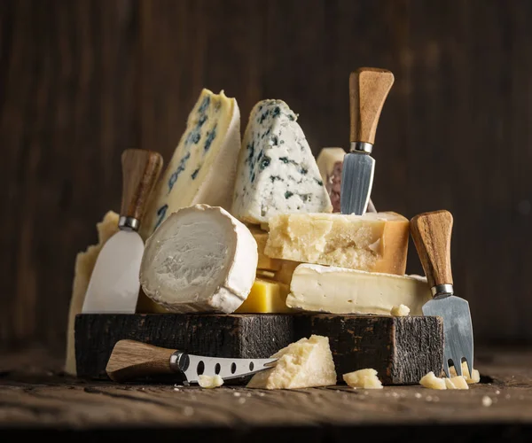 Assortiment de différents types de fromages sur fond en bois. Chees — Photo