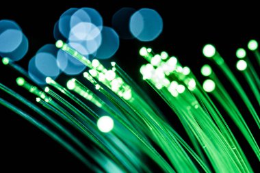 Yeşil ışığı olan bir yığın optik fiber. Siyah arkaplan.