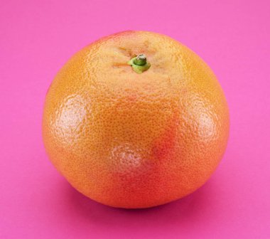 Pembe arka planda izole edilmiş mükemmel bir greyfurt.