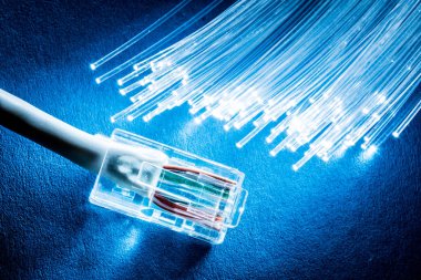 Mavi arka plan ışıklı ağ kablosu ve optik fiberler.