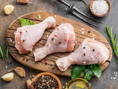 Baharatlar ve tuz yemek pişirmek için hazır tavuk budu. 