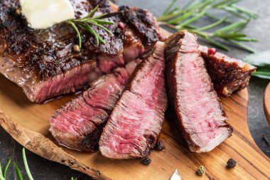 Otlar ve tereyağı bir parça ile Orta nadir Ribeye biftek