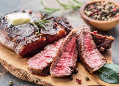 Otlar ve tereyağı bir parça ile Orta nadir Ribeye biftek