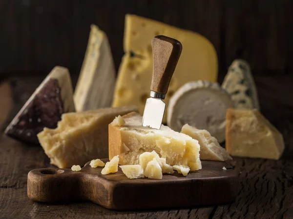 Кусок сыра Пармезан на деревянной доске. Ассортимент дифференциалов — стоковое фото