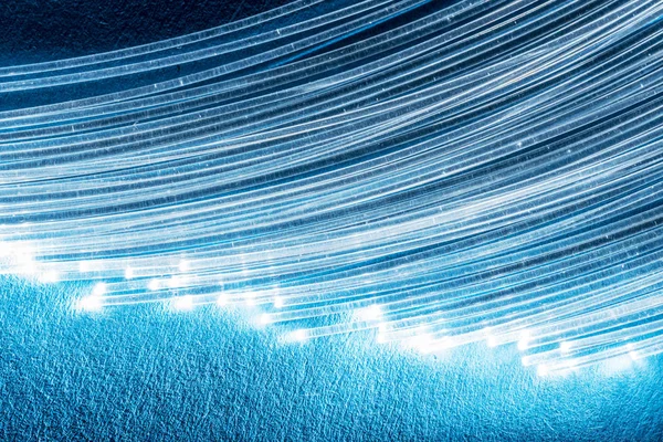 Paquete de fibras ópticas con luces en los extremos. Fondo azul. —  Fotos de Stock