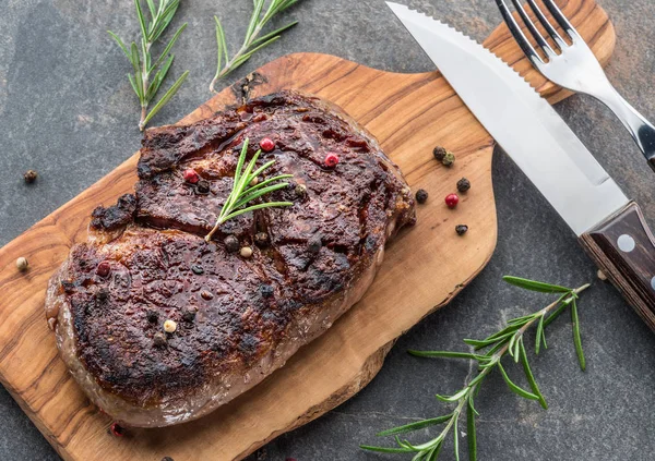 Otlar ve tereyağı bir parça ile Orta nadir Ribeye biftek