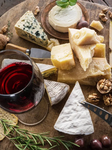 Piatto di formaggio con formaggi biologici, frutta, noci e vino su wo — Foto Stock