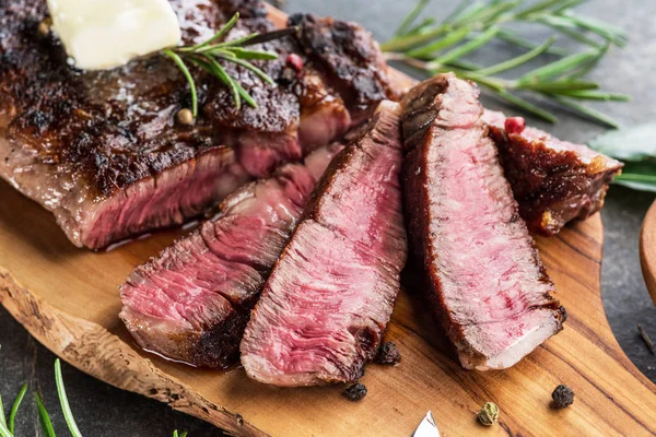 Mittelseltenes Ribeye-Steak mit Kräutern und einem Stück Butter auf der — Stockfoto
