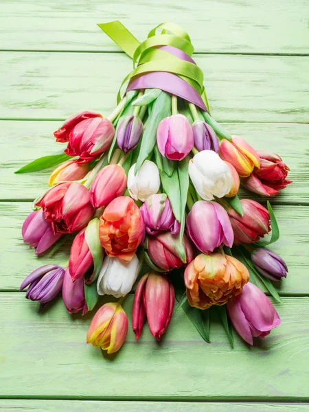 Bouquet colorato di tulipani su sfondo verde in legno . — Foto Stock