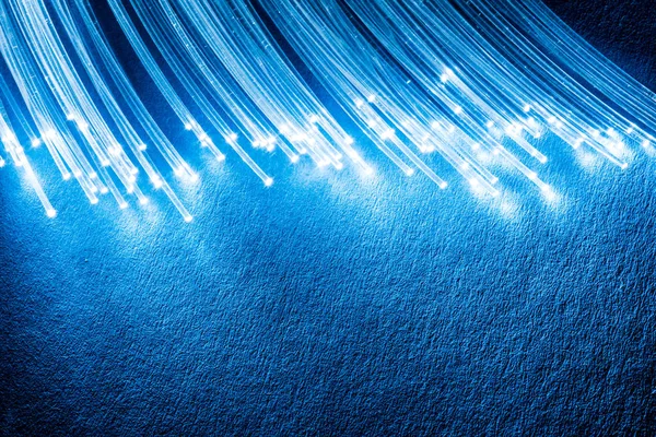 끝에 조명이 있는 광섬유 번들. 파란색 배경 — 스톡 사진