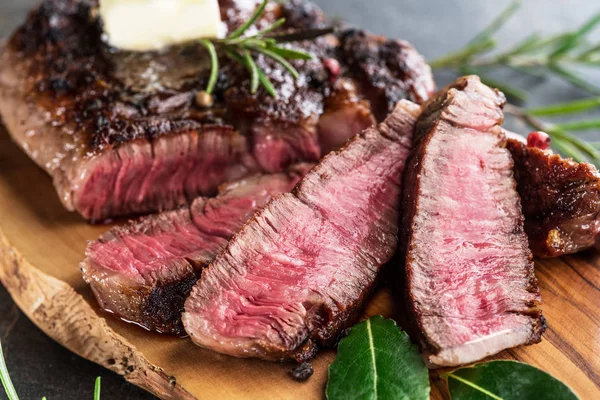 Mittelseltenes Ribeye-Steak mit Kräutern und einem Stück Butter auf der — Stockfoto