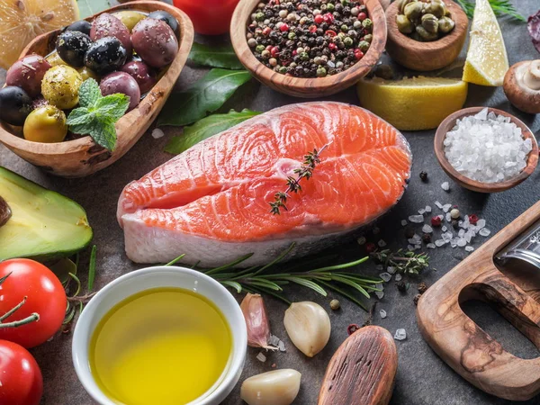 Salmón crudo con especias y verduras en el tablero de grafito . — Foto de Stock