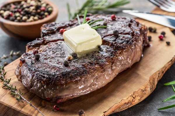 Medium rare Ribeye steak with herbs and a piece of butter on the — Free Stock Photo