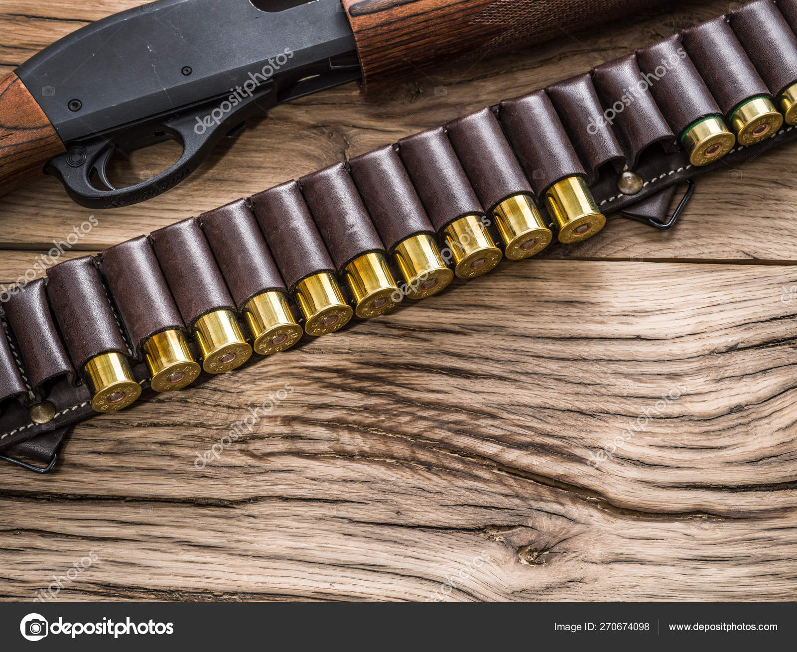 Pump action shotgun, 12 guage cartridge on the wooden table. Stock Photo by  ©Valentyn_Volkov 270674098