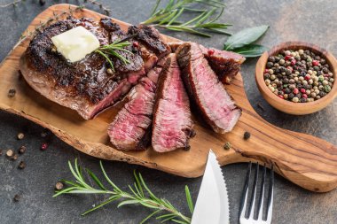 Otlar ve tereyağı bir parça ile Orta nadir Ribeye biftek