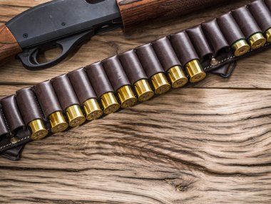 Pompa eylem av tüfeği, ahşap masa üzerinde 12 kalibre kartuş.