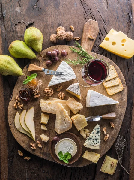 Bandeja de queso con quesos ecológicos, frutas, frutos secos y vino en wo —  Fotos de Stock