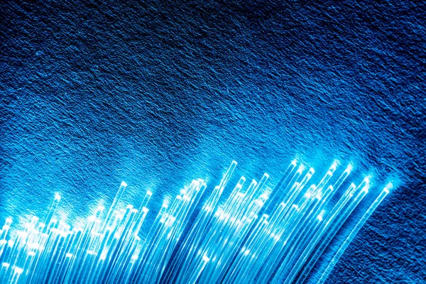 Bundle of optical fibers with lights in the ends. Blue backgroun — Stock Photo, Image