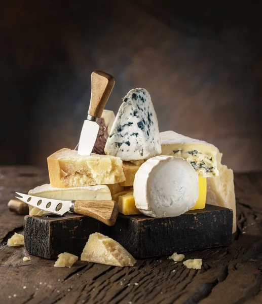 Sortiment av olika ostsorter på trä bakgrund. Chees — Stockfoto