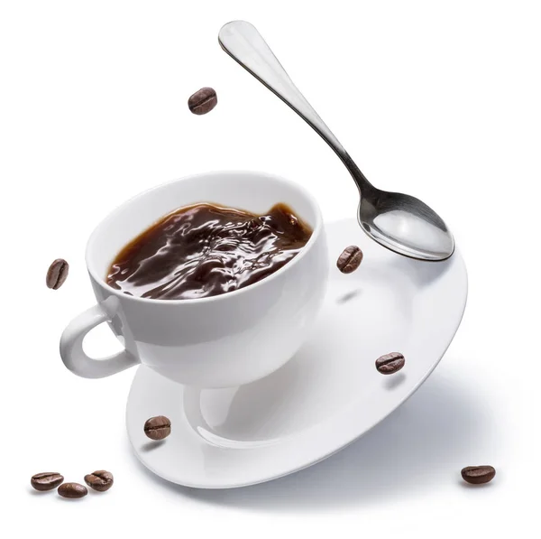 コーヒーカップ、コーヒー豆、スプーンが白い皿の上を飛ぶ — ストック写真