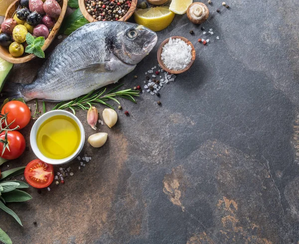 Surowe ryby dorado z przypraw i warzyw na płycie grafit — Zdjęcie stockowe