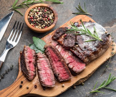 Otlar ve tereyağı bir parça ile Orta nadir Ribeye biftek