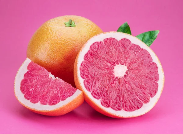 Grapefruit- und Grapefruitscheiben isoliert auf rosa Hintergrund. — Stockfoto