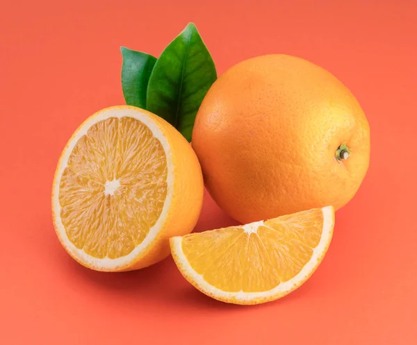 Fruta laranja com fatias de laranja e folhas isoladas em laranja ba — Fotografia de Stock