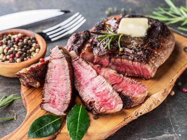 Medium zeldzame ribeye Steak met kruiden en een stukje boter op de — Stockfoto