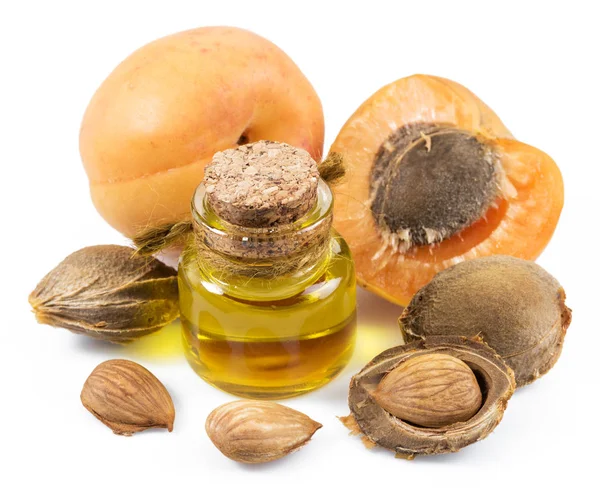 Apricot kernel oil and apricot kernels isolated on the white bac — Stock Photo, Image