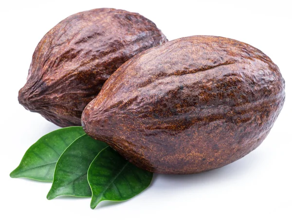 Cacao peulen met cacao bladeren geïsoleerd op een witte achtergrond. — Stockfoto