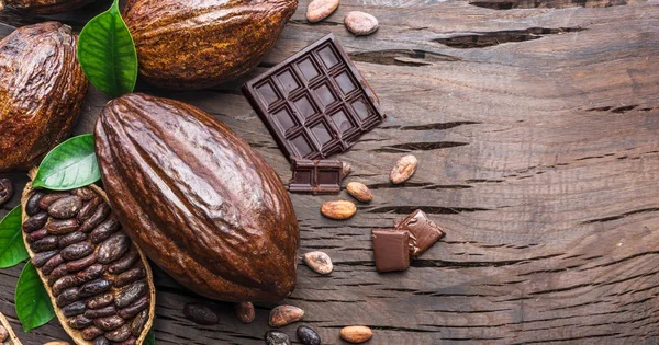 Vaina de cacao, granos de cacao y chocolate en la mesa de madera. Parte superior vi —  Fotos de Stock
