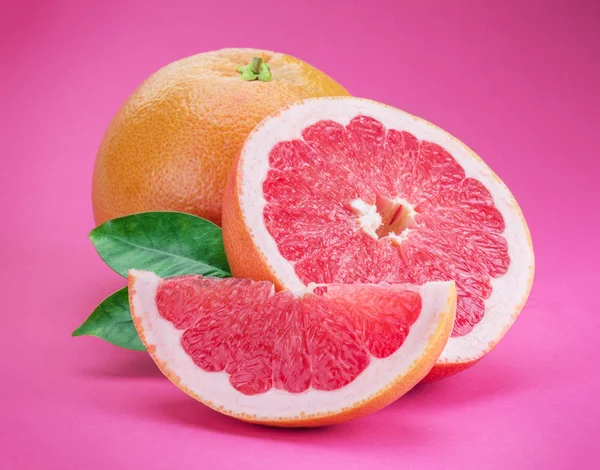 Grépfrút és grapefruit szeletek elszigetelt rózsaszín alapon. — Stock Fotó