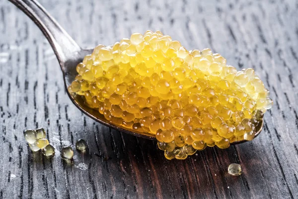 Pike caviar or roe in spoon on wooden background. — Stock Photo, Image