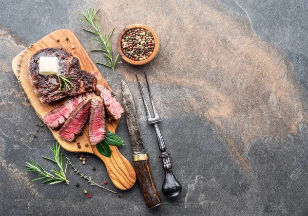 Medium zeldzame ribeye Steak met kruiden en een stukje boter op de — Stockfoto