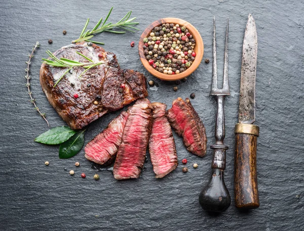 Steak Ribeye langka sedang dengan herbal di papan grafit . — Stok Foto