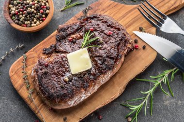 Otlar ve tereyağı bir parça ile Orta nadir Ribeye biftek