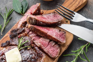 Otlar ve tereyağı bir parça ile Orta nadir Ribeye biftek