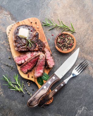 Otlar ve tereyağı bir parça ile Orta nadir Ribeye biftek