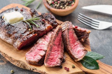 Otlar ve tereyağı bir parça ile Orta nadir Ribeye biftek