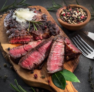 Otlar ve tereyağı bir parça ile Orta nadir Ribeye biftek