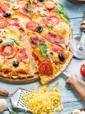 Mantar, salam ve domates pizza.